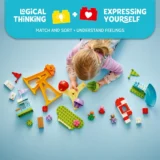Child Playing with Colorful Lego style Toys on a Blue Floor Exploring Shapes and Building Blocks with a Bright Educational Banner at the Top Saying 'logical Thinking' and 'expressing Yourself'