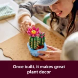 Person Wearing a Cap Builds a Blue Planter with Pink Cactus Flowers Close up of Hands on a Craft Project Image Overlay Reads 'once Built It Makes Great Plant Decor'