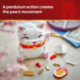 White Lego style Cat Toy with Closed Eyes and Pink Cheeks Sitting on a Surface with Small Red Tan and White Pieces Scattered Nearby