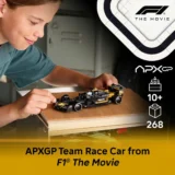 Child Assembling a Model Formula 1 Car on a Wooden Board with Apxgp Branding and 'the Movie' Logo on the Right