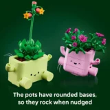 Two Cute Lego Planters with Rounded Bases lime Green and Pink Wobbling Under Leafy Plants Against a Dark Green Backdrop with a Caption About the Pots Rocking when Nudged