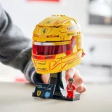 Yellow Lego Race Helmet on a Display Stand with Sponsor Decals Beside a Small Lego Driver Figure and a Sign Reading Lewis Hamilton