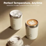 Two Cream colored Insulated Tumblers on a Beige Surface One with Ice and the Other with Latte Art in an Ad like Setup