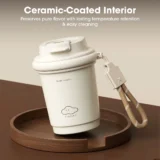 Cream colored Insulated Travel Mug with a Ceramic coated Interior Sits on a Round Wooden Tray Attached Beige Strap and Marketing Banner Text Above Reading 'ceramic coated Interior'