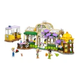 Colorful Lego Cafe Scene with a Storefront Outdoor Seating Purple Blossoms and a Yellow Tram on the Left