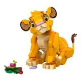 Orange Lego Lion Cub Tilting Its Head Sitting on Tan Bricks a Small Green Base with a Pink Piece and a Red Ladybug Nearby