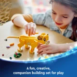 Girl Playing with a Yellow Brick built Lion on a Table During a Creative Building Session