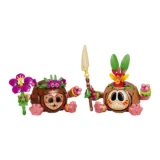 Two Colorful Tiki style Characters with Brown Shells Pink Hands and Flower Decorations Stand Side by Side One Wields a Spear the Other Raises a Fist