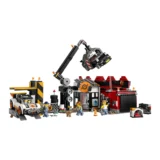 Lego City Scene with a Crane Lifting a Vehicle over a Workshop a Red Building Workers a Tow Truck and Scattered Tools and Crates