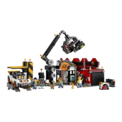 Lego City Scene with a Crane Lifting a Vehicle over a Workshop a Red Building Workers a Tow Truck and Scattered Tools and Crates