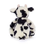 Back View of a Plush Cow Stuffed Toy with Black and White Spots Pink Ears and a Fluffy Tail Sitting on a White Surface