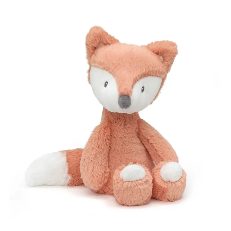 Soft peach-colored plush fox stuffed animal sitting upright with white paws and tail on a white background.